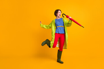 Full length photo portrait of funky woman singing into umbrella standing on one leg isolated on...