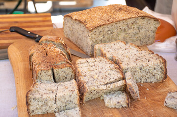 Homemade brown fragrant fresh cereals bread on a rustic wooden board, close up