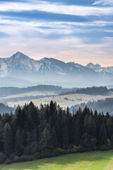 Meadows and Pasture on Rolling Hills with Snow Covered Tatra Mountains in Poland at Fall