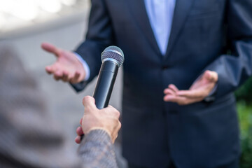 Close-up of male hands holding microphone during interview