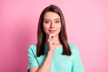 Photo portrait of thoughtful curious girl smiling touching chin with hand isolated on pastel pink color background