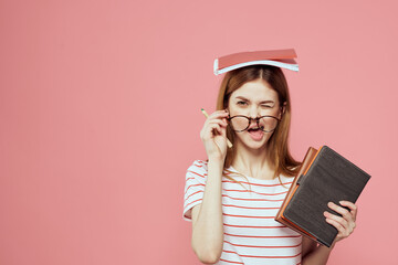 beautiful female student holding books education institute gesturing with hands pink background...