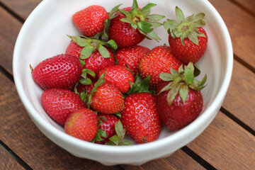 a cup of strawberries in white bowl