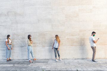 Young people standing in line to coronavirus pandemic safety