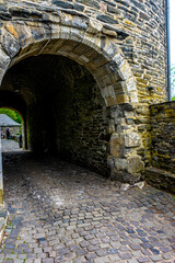 Obraz premium Germany, Monschau, a stone building that has a bridge next to a brick wall
