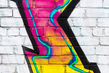 A fragment of colorful graffiti painted on a brick wall. Abstract backdrop for design.