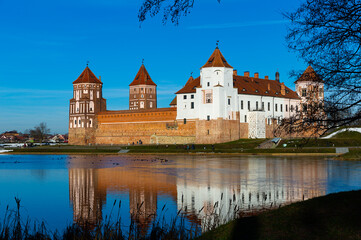 Naklejka na ściany i meble View of impressive medieval Castle surrounded by ponds in Belarusian town of Mir on winter day