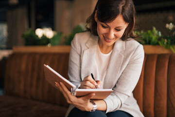 Casually dressed, writing about her day.