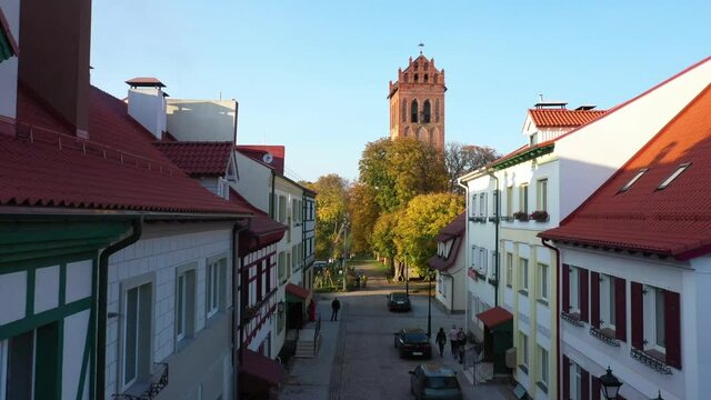 The restored facades of the Zheleznodorozhny town against the background of an abandoned old Prussian church, Russia, autumn time