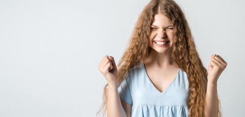 Portrait of happy cheerful young girl smiling rejoicing with closed eyes. Studio shot, white background
