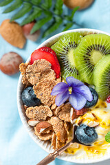 Obraz na płótnie Canvas Breakfast with fresh Greek yogurt, strawberries, kiwi and granola on a light concrete background. Healthy food nutrition, snack or breakfast.