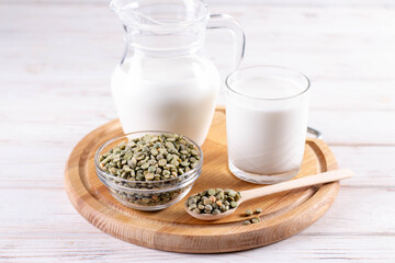 Dry peas, a glass of milk and pea vegetable milk in a milk jug on a white wooden table. Gluten-free, soy free, lactose-free product