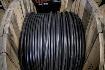 Fototapeta na wymiar Wooden Coils Of Electric Cable Outdoor. High and low voltage cables in the storage