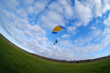 Skydiving. A parachutist is landing. Fish-eye view.