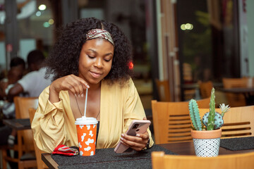 image of beautiful african lady, with smart phone, food and drink concept
