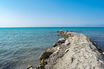 A breakwater in Astrakeri, Corfu, Greece with a view of the Ionian Sea