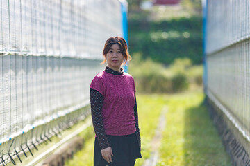 秋の朝の公園で散歩している主婦の様子