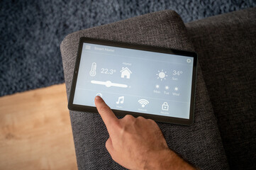 modern smart home control app with flat interface on a black tablet display lies on the back of a...