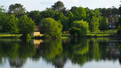 Fototapeta na wymiar Cadre idyllique printanier aux abords d'un étang, dans un village des Landes de Gascogne