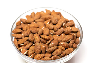 Closeup raw peeled almonds in glass bowl on white background, organic fresh nuts, natural delicious snack, cooking baking ingredients. Healthy vegetarian food concept, almonds benefits, vitamins