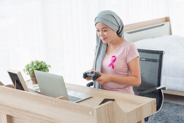 women wearing pink ribbons with game joystick in bedroom