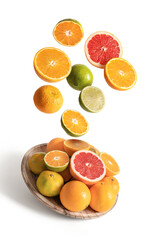 Wood dish with assorted oranges and tangerines flying, isolated from the white background