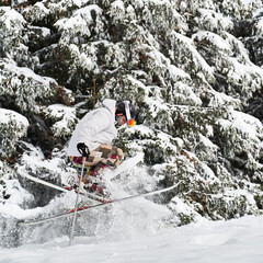 Skier doing tricks in the mountains in winter season, jumping on slope merging with beautiful snowy...