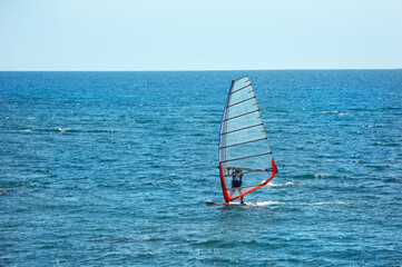 The man is engaged in windsurfing in the open sea.