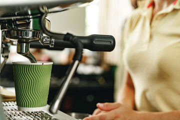 Fototapeta na wymiar Woman coffee shop worker preparing coffee on professional coffee machine
