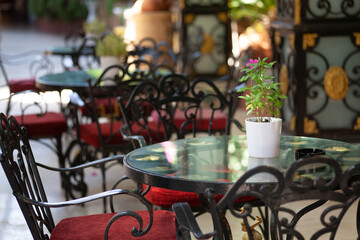 Forged table and chairs in a street cafe in Antalya, Turkey. Cozy place in the shade to relax