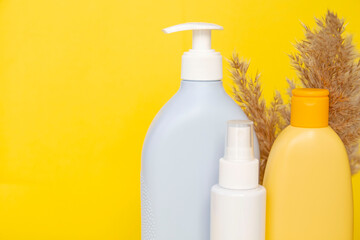 Group of cosmetic bottles isolated on yellow background