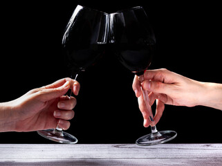 Brindando con dos copas de vino negro