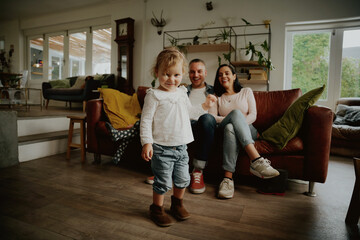 Smiling toddler girl standing ready to dance at home