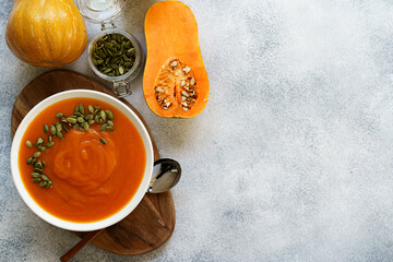 Top view of pureed pumpkin soup in a white bowl on dark table