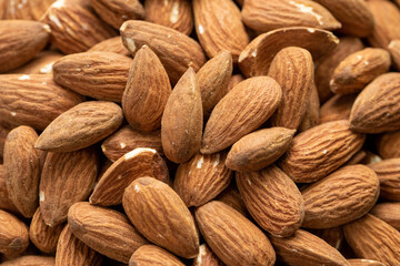 Background of big raw peeled almonds, macro shot of organic fresh tasty nuts, natural delicious snack, cooking baking ingredients. Nuts texture closeup. Healthy vegetarian food concept, text space