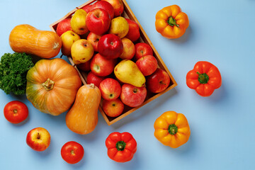 Pumpkins, apples and bell pepper composition on blue background