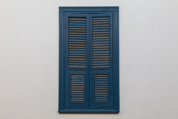 Closed blue window on light wall