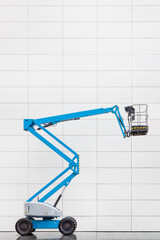 Modern blue hydraulic lift platform in front of a white tiled office wall © Martin Bergsma