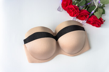 classic bra. nude and strapless bra on white background with rose flowers. Black and beige nude...