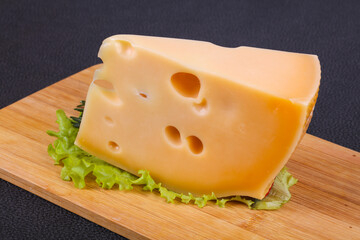 Maasdam cheese  in the board served salad leaves