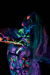 Fototapeta premium Art woman body art on the body dancing in ultraviolet light. Bright abstract drawings on the woman body neon color. Colored hair and face