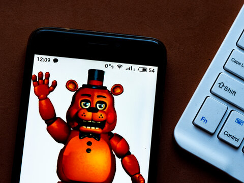 In this photo illustration a Five Nights at Freddy's. appliance by Clickteam, LLC. logo is seen displayed on a smartphone