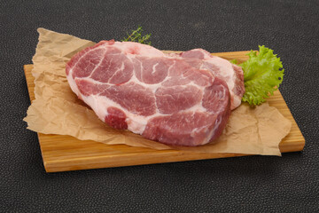 Raw pork steak over wooden board