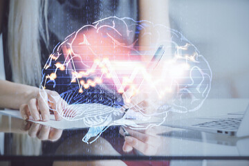 Multi exposure of woman's writing hand on background with brain hud. Concept of learning.