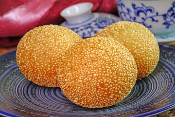 Sesame Ball is fried dessert balls made of flour stuffed with seasoning mung bean, red bean, black bean or peanut paste and coated with white sesame. Also known as Dragon balls, Famous  Chinese snack