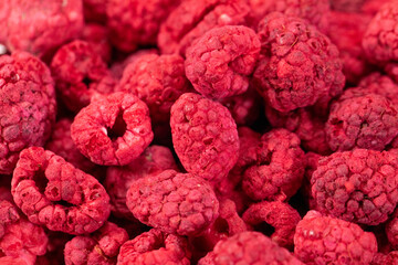 Macro shot of freeze dried organic raspberries, raw delicious snack, cooking baking ingredients. Pink berries background. Natural sugars, healthy food, fresh fruits, mindful eating concept, text space