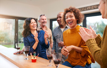 Group Of Mature Friends Meeting At Home To Celebrate Womans Birthday With Cake