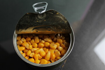 yellow sugar corn in a tin metal can on a dark background of copy space