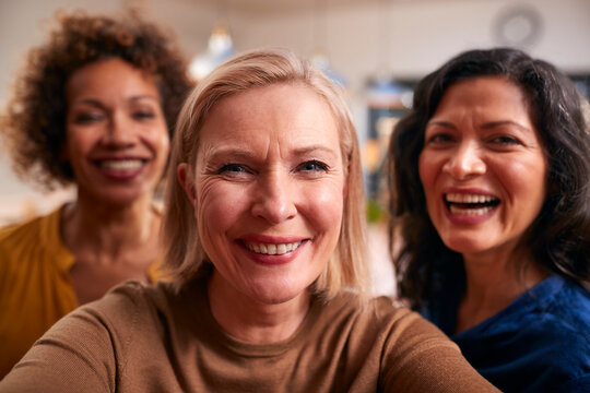 Group Of Mature Female Friends Posing For Selfie On Mobile Phone At Home