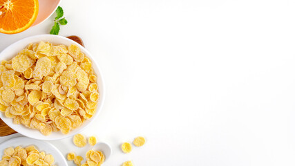 Top view of corn flakes bowl with milk on white background.